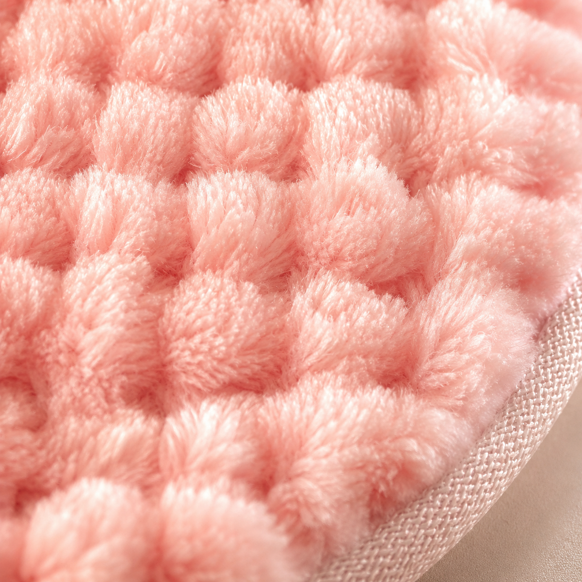 Extreme close up of the soft plush fibres and woven edge of the DOLLSFACE® HALO facial cleansing pad.