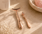 DOLLSFACE® rose gold Ritual Bars for facial massage, shown together on a warm stone surface.